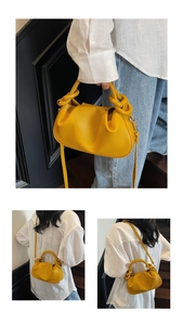 Detail of yellow cloud bag with pleated texture and stylish knotted handle design