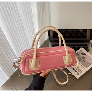 Detail showing pink and cream PU leather handbag with stitching and zipper closure