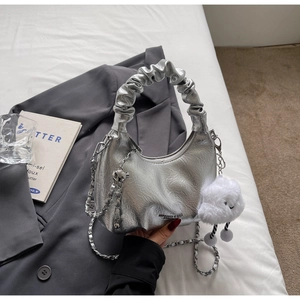 Close-up of silver pleated bag with metallic crinkle texture and white plush cloud charm