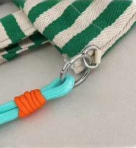 Détail du sac en toile rayé vert avec crochet métallique robuste et sangle tissée