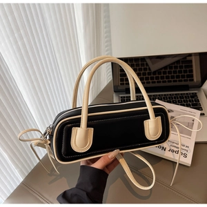 Detail of minimalist black and white contrast shoulder bag with leather texture and strap