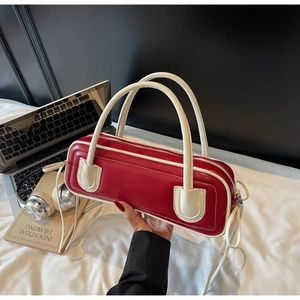 Detailed close-up of a red and white bowling-style handbag with metal zipper details