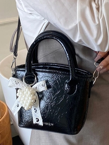 Secchiello minimalista in pelle verniciata nera con fiocco in pizzo e ciondolo a cuore