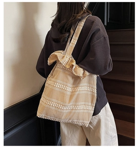 Detail of yellow gingham tote bag featuring ruffle edges and canvas shoulder strap
