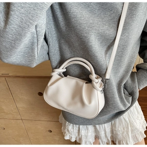 Detail view of white lychee pattern cloud bag with knotted handle and slim strap