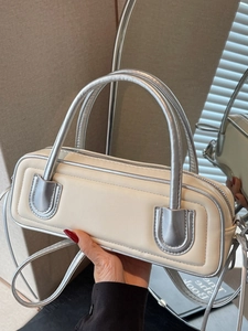 Minimalist beige rectangular underarm bag with silver metal handles and U-shaped details