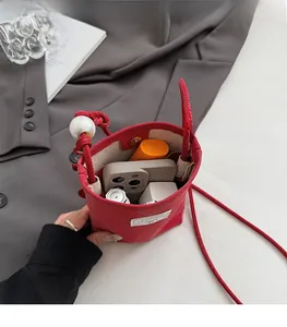 Interior view of a red drawstring bucket bag showing storage space for mobile and cosmetics