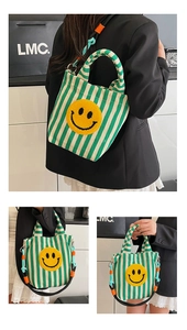 Détail du sac en toile rayé vert avec patch smiley jaune et bandoulière tissée