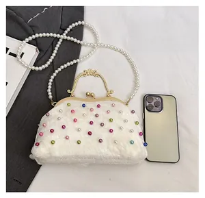 Dettaglio della borsa da sera in pizzo bianco con perline colorate e tracolla di perle