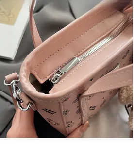 Détail de la fermeture éclair argentée et de la texture en cuir rose du sac à main