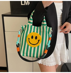 Vue détaillée du sac en toile rayé vert et blanc avec broderie smiley jaune sur le devant