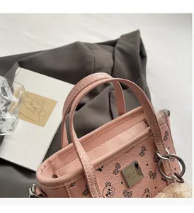 Détail du sac cabas en cuir rose avec logo en métal et motif ours et nœud mignon