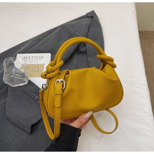 Detail of ginger yellow lychee leather cloud bag with a unique knot-design top handle