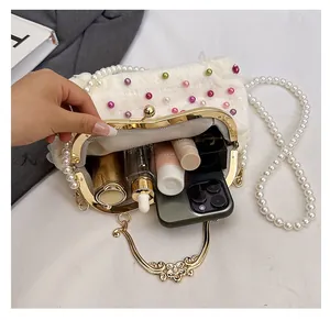 Dettaglio interno della borsa con perle che mostra la capienza per cellulare e cosmetici