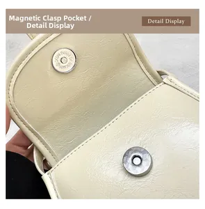 Detail view of the magnetic buckle closure on a beige lychee pattern crossbody phone bag
