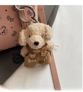 Détail d'un porte-clés chien en peluche avec une salopette en velours et anneau argenté
