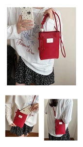 Detail of red mini crossbody phone bag with woven strap and pearl heart charms