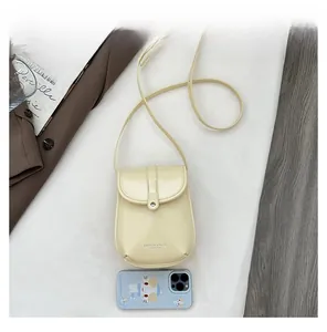 Detail view of cream mini crossbody phone bag with magnetic flip cover and leather texture