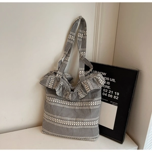 Detail of black and white checkered canvas tote bag with ruffled lace trim edge