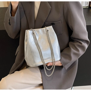 Silver metallic bucket bag with chain strap styled with a charcoal blazer for a chic look