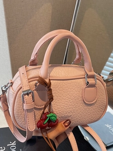 Pink minimalist crossbody pillow bag with cherry charm and textured leather handles