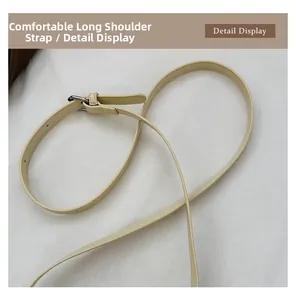 Detail display of the cream leather adjustable long shoulder strap with silver metal buckle