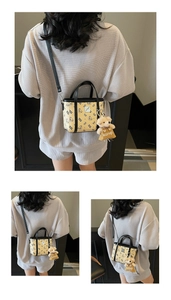 Détail d'un mini sac jaune avec motifs d'ours et pendentif ours en peluche amovible