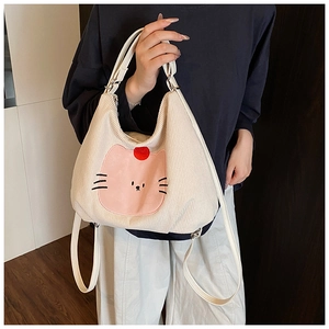 Detailed view of white corduroy tote bag featuring pink cat embroidery and soft texture