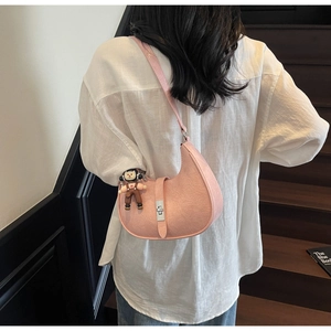 Pink crescent hobo bag with cracked leather texture and silver buckle on a model