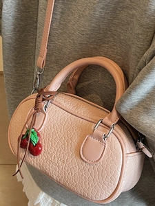 Pink cylinder crossbody bag with cherry charm and textured leather for women