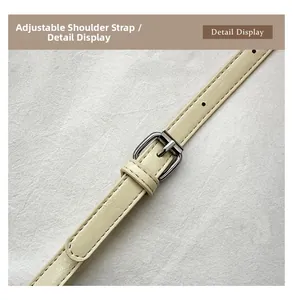 Close-up of adjustable cream leather shoulder strap with silver buckle and fine stitching