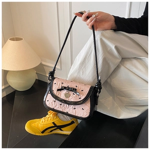 Close-up of pink ruched underarm bag with black bow detail and heart pendant