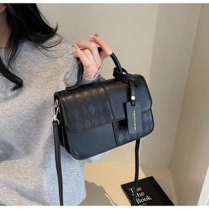 Detail of black crossbody bag with quilted panel and Fashion and Bags lettering