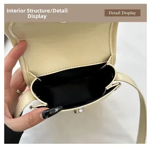 Detail view showing single compartment and magnetic closure of the beige PU leather bag