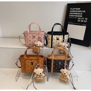 Détail de sacs à main tendance en similicuir avec imprimés d'ours et breloques en peluche