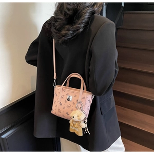 Mini cabas rose avec imprimé ours, plaque logo argentée et peluche sur un mannequin