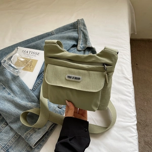 Vista dettagliata della borsa a tracolla in nylon verde chiaro con tasca frontale