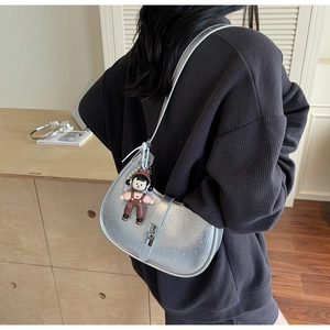 Silver crescent shoulder bag with metallic cracked texture and cute doll charm