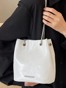 Large white glossy leather bucket bag with silver chain strap and metal details