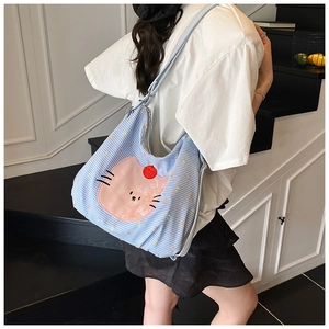 Detail view of light blue checkered tote bag featuring a cute pink cartoon cat print