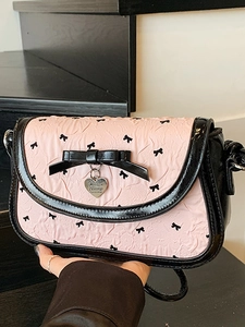 Pink bow shoulder bag with black trim and heart pendant for a sweet vintage aesthetic