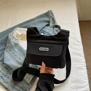 Dettaglio della borsa a tracolla minimalista in nylon nero con tracolla regolabile