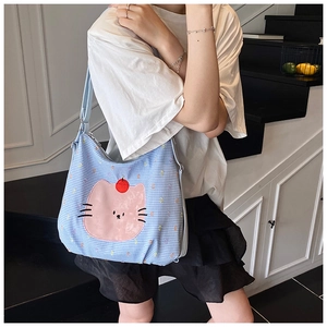 Close-up of light blue checkered tote bag featuring a cute pink cat cartoon print