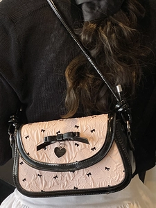 Pink bow shoulder bag with black ribbon prints and a metallic heart charm for women