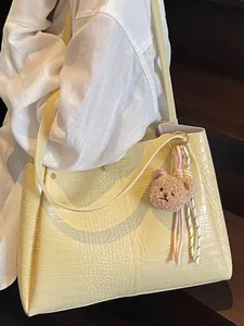 Large cream crocodile texture tote bag with plush bear charm and thin shoulder straps