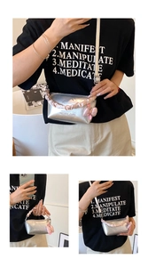 Détail du sac polochon argenté avec poignée en satin rose et décoration nœud