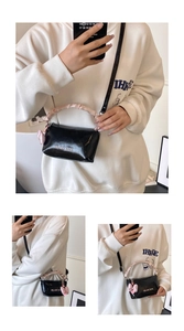 Détail du sac polochon noir brillant avec poignée froncée rose et nœud décor