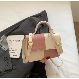 Detail of pink and beige square bag with quilted texture and gold hardware accessories