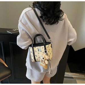 Mini sac à main beige tendance avec imprimé ours noir et charmant accessoire en peluche