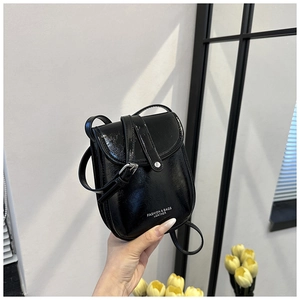 Close-up of black glossy mini crossbody phone bag with silver buckle and fashion logo